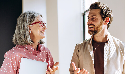 A man and woman gesturing and smiling at each other
